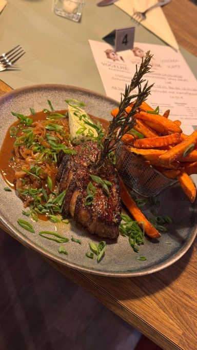 Rumpsteak mit Süßkartoffeln und Kräutern auf einem Teller angerichtet.